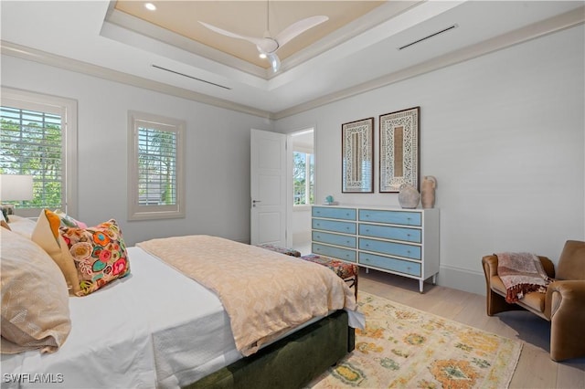 565 Anchor Rode Dr, Naples, FL 34103 - bedroom featuring a tray ceiling, multiple windows, recessed lighting, and light wood finished floors