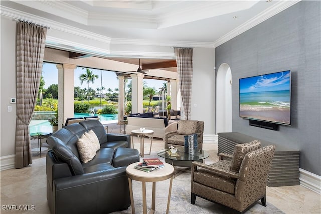 living room with ornamental molding, a raised ceiling, and a healthy amount of sunlight