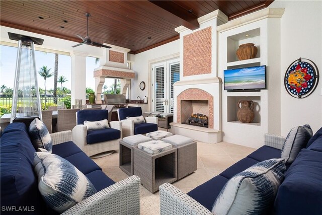 living area with ornamental molding, ceiling fan, light tile patterned flooring, and wood ceiling