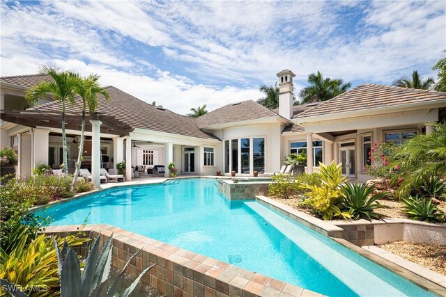 view of pool featuring a patio area, a pool with connected hot tub, and french doors