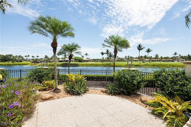 view of patio featuring a water view and fence