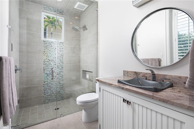 bathroom featuring an enclosed shower, vanity, tile patterned flooring, and toilet