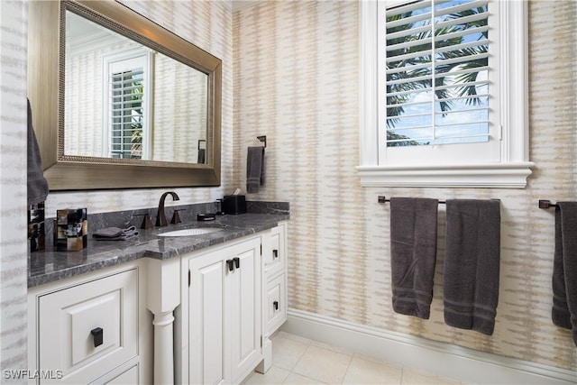 bathroom featuring tile patterned floors, vanity, baseboards, and wallpapered walls