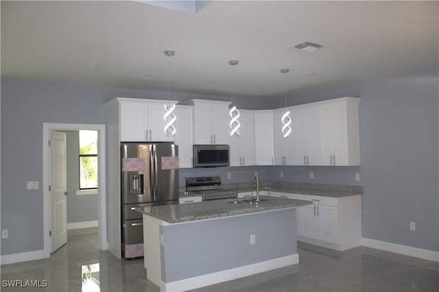 kitchen featuring sink, decorative light fixtures, a center island with sink, stainless steel appliances, and white cabinets