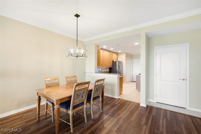 dining area with ornamental molding, light hardwood / wood-style flooring, and a notable chandelier