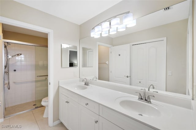 bathroom with vanity, tile patterned flooring, toilet, and walk in shower