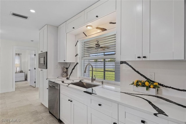 kitchen with stainless steel appliances, sink, white cabinets, and ceiling fan