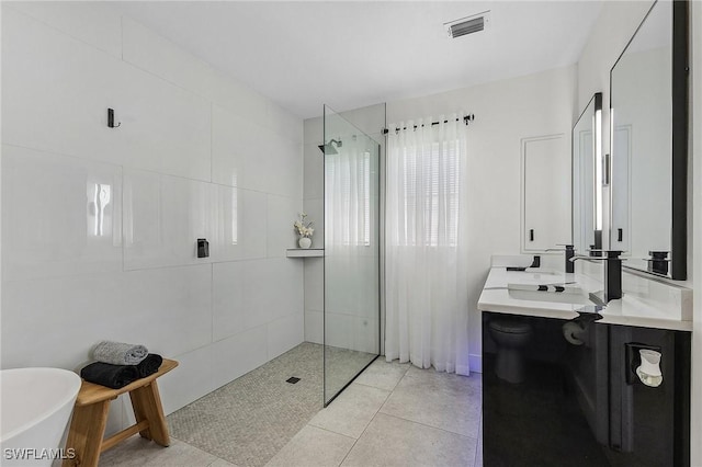 bathroom featuring shower with separate bathtub, tile patterned floors, and vanity