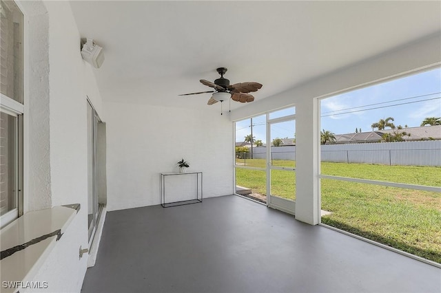 unfurnished sunroom with ceiling fan