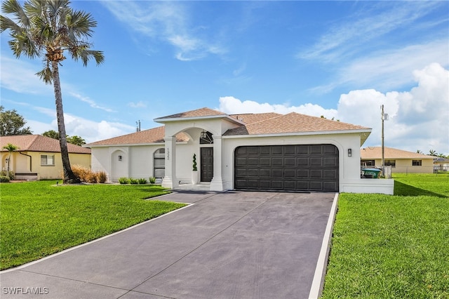 mediterranean / spanish house with a garage and a front lawn