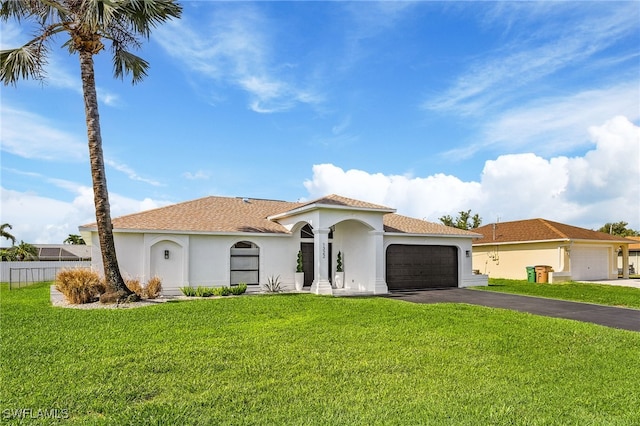 mediterranean / spanish home featuring a garage and a front yard