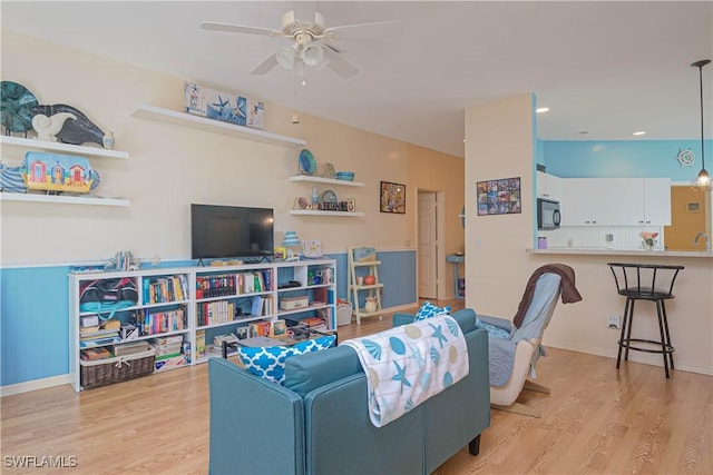 living room featuring ceiling fan and light hardwood / wood-style flooring