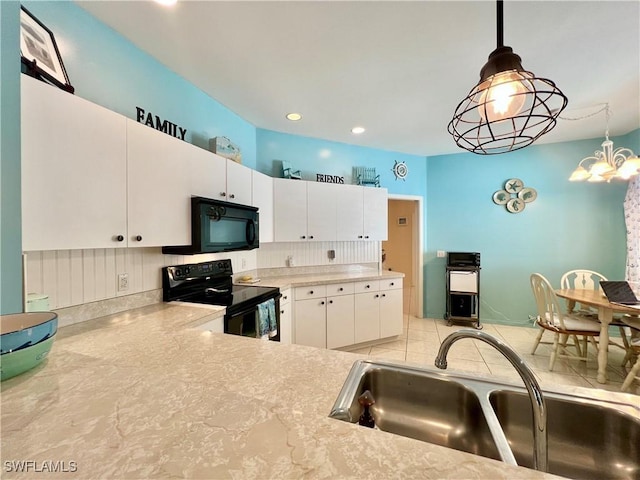 kitchen with light countertops, hanging light fixtures, white cabinets, a sink, and black appliances