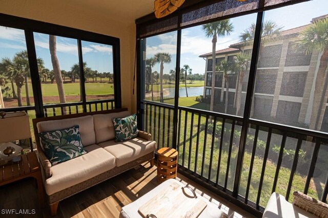 sunroom featuring a water view