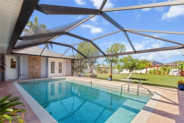 view of pool featuring a patio, a lawn, glass enclosure, and french doors