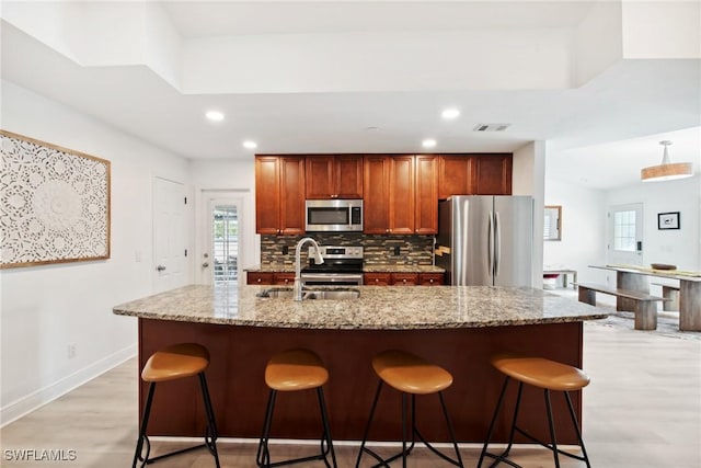 kitchen featuring tasteful backsplash, appliances with stainless steel finishes, sink, and a breakfast bar area