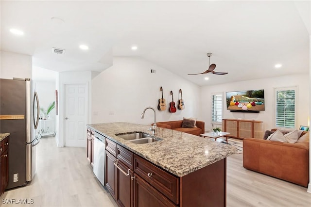 kitchen with sink, appliances with stainless steel finishes, an island with sink, light stone countertops, and light hardwood / wood-style floors