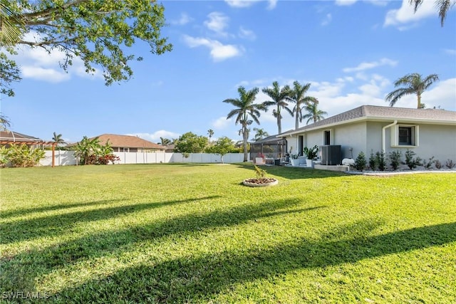 view of yard with a lanai and central AC unit