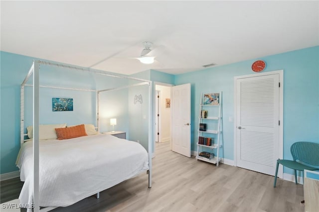 bedroom with ceiling fan, a closet, and light hardwood / wood-style flooring