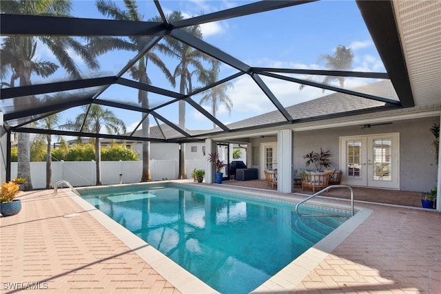 view of swimming pool with french doors, a patio area, glass enclosure, outdoor lounge area, and ceiling fan