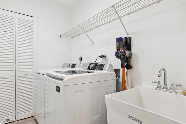 laundry area with separate washer and dryer and sink