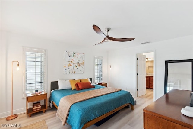 bedroom with ceiling fan, ensuite bath, and light hardwood / wood-style floors