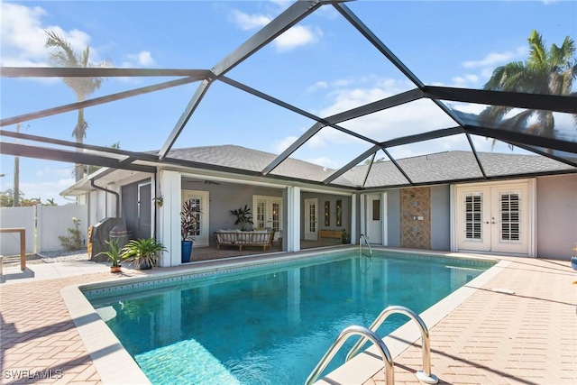 view of swimming pool featuring french doors, ceiling fan, a lanai, and a patio