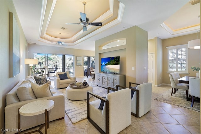 tiled living room with crown molding, ceiling fan, and a tray ceiling