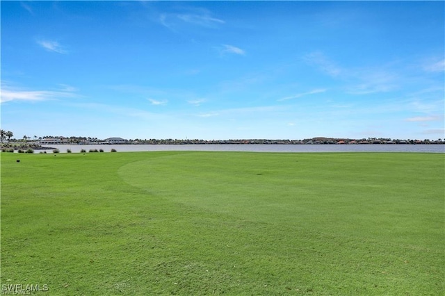 surrounding community with a water view and a yard