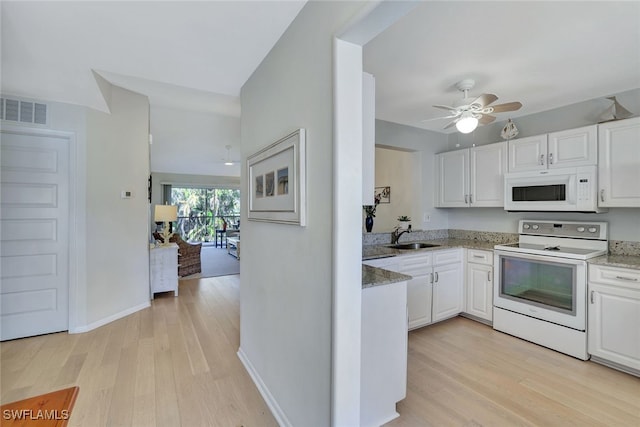 kitchen featuring white appliances, sink, light hardwood / wood-style flooring, and white cabinets