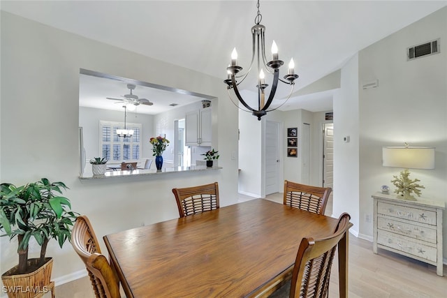 dining space with ceiling fan with notable chandelier and light hardwood / wood-style floors