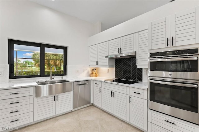 kitchen with light tile patterned floors, sink, appliances with stainless steel finishes, backsplash, and white cabinets