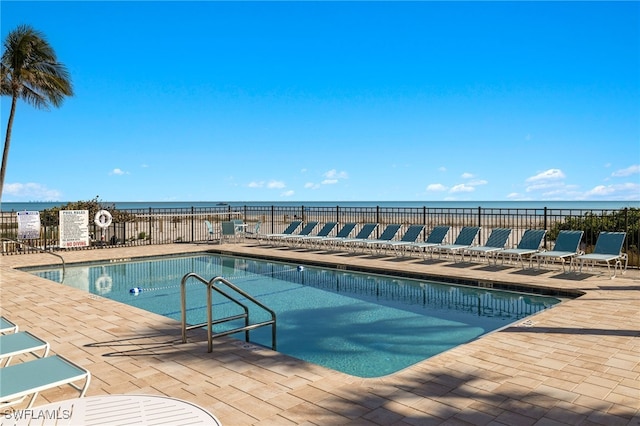 view of pool with a patio and a water view