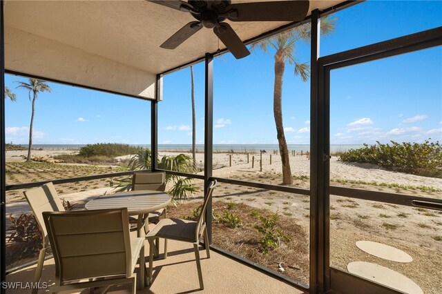 sunroom featuring a rural view and ceiling fan