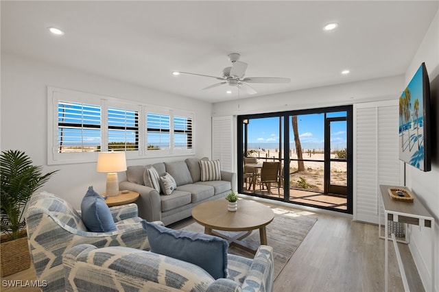 living room featuring ceiling fan and light hardwood / wood-style floors