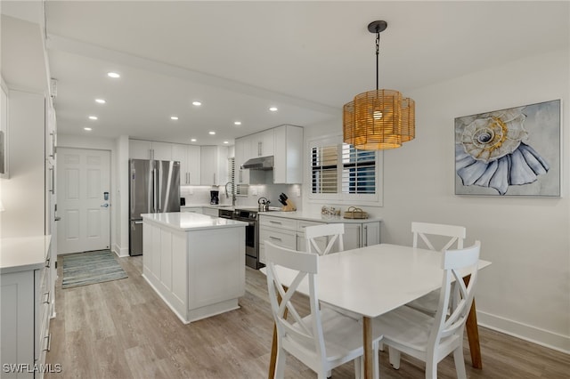 dining room featuring sink and light hardwood / wood-style floors