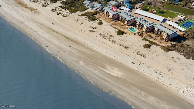 birds eye view of property with a water view and a beach view