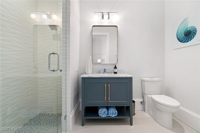 bathroom with toilet, a stall shower, vanity, and baseboards