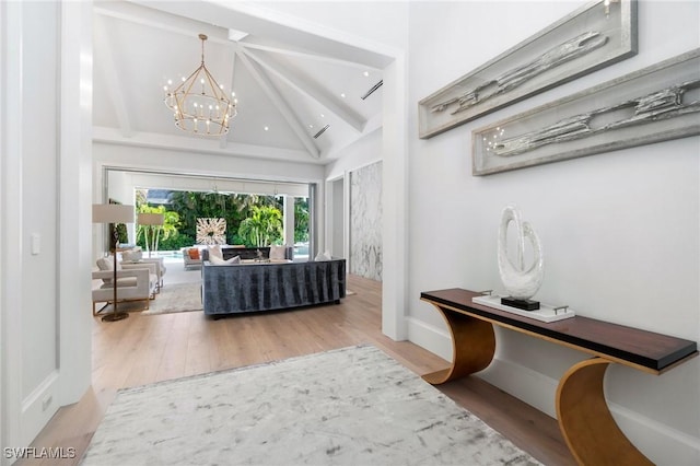 entryway featuring beamed ceiling, high vaulted ceiling, a chandelier, and wood finished floors