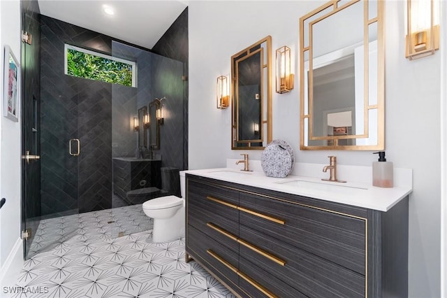 bathroom with a sink, a shower stall, toilet, and double vanity