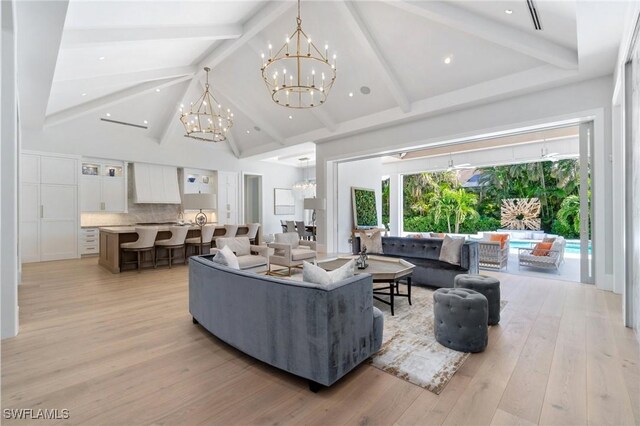 living room with beam ceiling, high vaulted ceiling, a chandelier, and light wood-type flooring