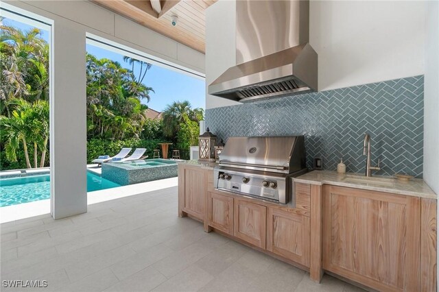 view of patio / terrace featuring a grill, sink, exterior kitchen, and a pool with hot tub