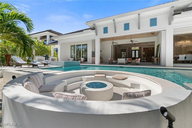 rear view of house with an outdoor living space with a fire pit, ceiling fan, and a patio area