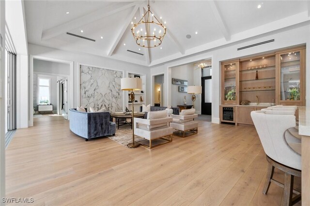 living room featuring light hardwood / wood-style flooring, high vaulted ceiling, wine cooler, a notable chandelier, and beamed ceiling