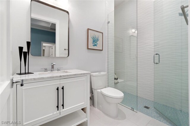 bathroom featuring tile patterned flooring, vanity, walk in shower, and toilet