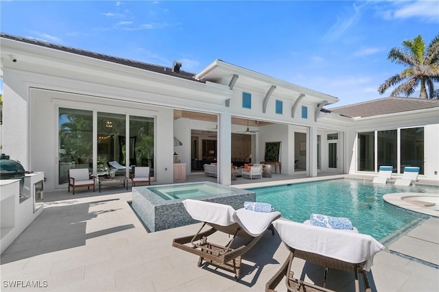 rear view of property featuring a patio, outdoor lounge area, an in ground hot tub, exterior kitchen, and an outdoor pool