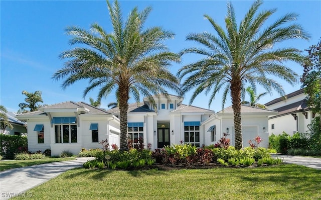 view of front facade with driveway, a front lawn, an attached garage, and stucco siding