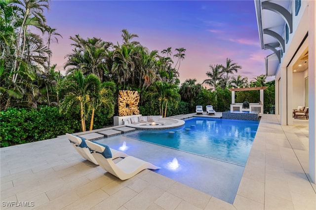 outdoor pool with a patio area and a jacuzzi