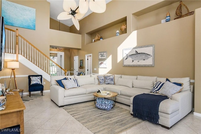 living room with a high ceiling, light tile patterned floors, and ceiling fan