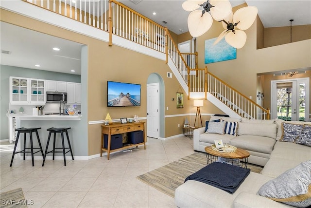 tiled living room featuring french doors and a high ceiling